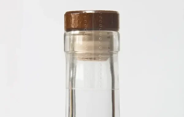 Learn how bottle neck and shoulder shape affect shrink sleeve fit, closure compatibility, tamper evidence, artwork distortion, material choice, sample testing, and RFQ preparation for spirits packaging.